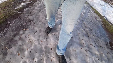 Man dressed in blue jeans walks in the snow on a winter day. Video stock 102425852
