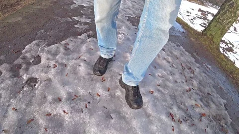 Man dressed in blue jeans walks in the snow on a winter day. Stock Footage 102425875