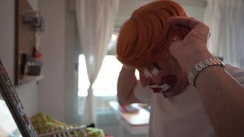 Man dressed as clown preparing for performance 스톡 동영상 323804491