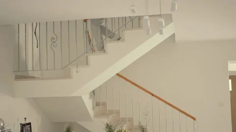 A man dressed in elegant gray clothes descends the stairs inside the house Stock Footage 226760418