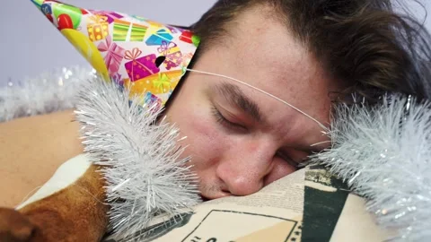 Man dressed in festive cap with tinsel sleeps deeply Stock Footage 274686473