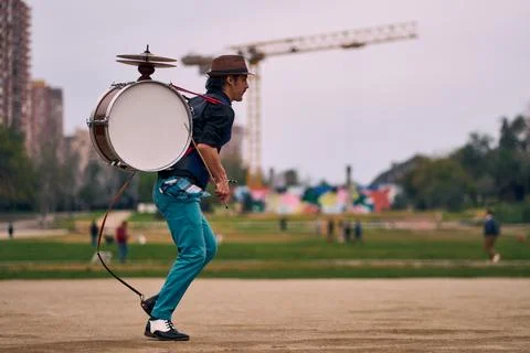 Man dressed in formal and colorful clothing, spinning and playing Stock Photos