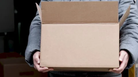 A man dressed is holding a brown delivery box in hands 库存影片 166119056