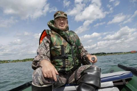Man dressed in a life jacket operates a motor boat Foto stock
