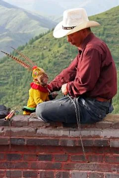 Man with a dressed-up monkey entertaining tourists on the way to a temple in Stock Photos