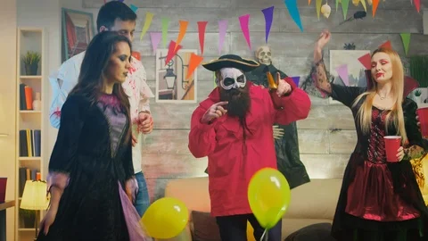 Man dressed up like a pirate dancing with people dressed up like different Stock Footage 126980279