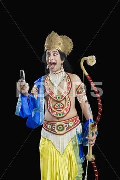 Man dressed-up as Rama reading text message Stock Photos