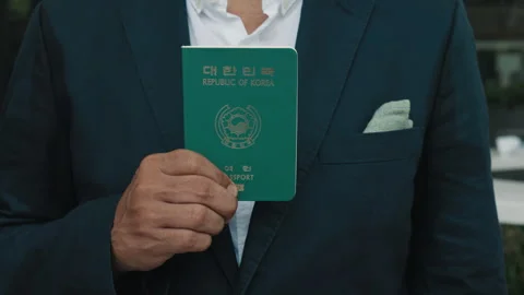 Man dressed in stylish blazer demonstrates Korean travel passport Stock Footage 279918822