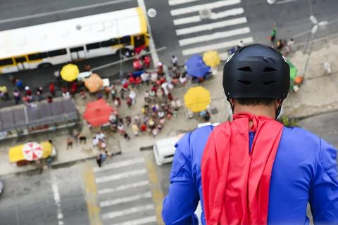 Man dressed as a superhero rappelling down from a tall building. Fotos de archivo