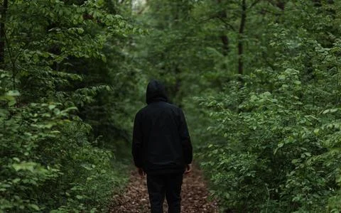 A man dressed in  walks through the forest Stock Photos
