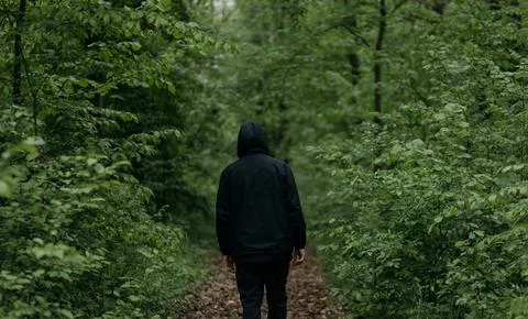 A man dressed in  walks through the forest Stock Photos