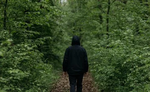 A man dressed in  walks through the forest Stock Photos