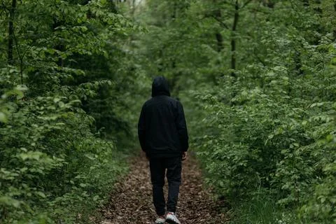 A man dressed in  walks through the forest Stock Photos
