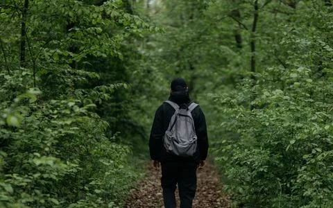 A man dressed in  walks through the forest Stock Photos