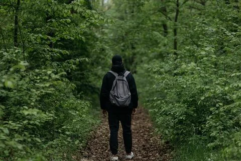 A man dressed in  walks through the forest Stock Photos