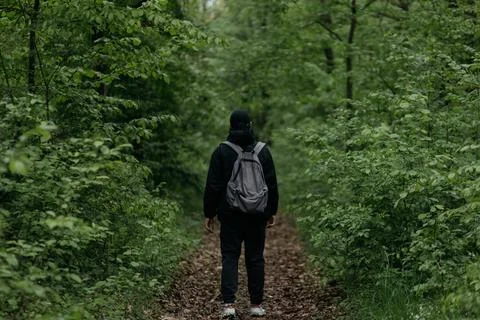 A man dressed in  walks through the forest Stock Photos