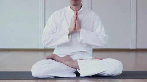 A Man Dressed in White Practices Yoga. He Folded his arms and namaste Stock-Footage 59729527