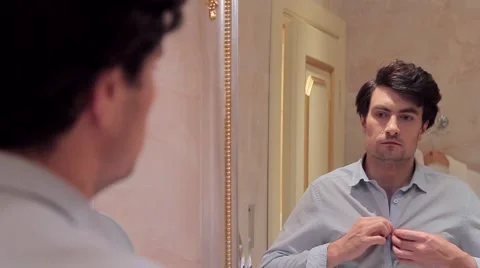 Man dressing up and looking himself in mirror Stock Footage 66745341
