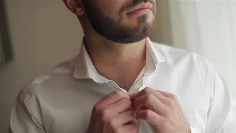 Man dressing close-up shallow dof. Male hands buttoning white shirt quickly Stock Footage 72371027