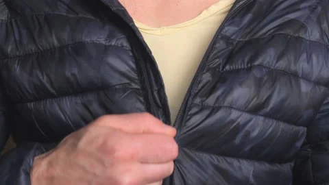 Man dressing to go outside, closing zipper on jacket. Body close up Stock Footage 194517349