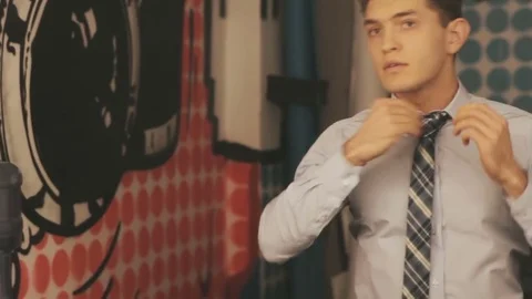 Man is dressing himself up in front of a mirror Stock Footage 76510145