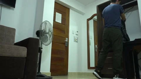 A man dressing in a jacket in a hotel room and going out at night in 4k 库存影片 196737910