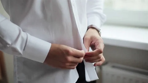Man dressing near window close up shallow depth field. Male hands button shirt Vidéo 71007228