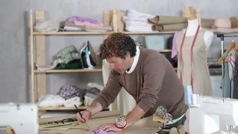 Man dressmaker drawing pattern on paper in workshop Stock Footage 341426897
