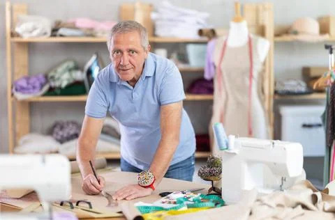Man dressmaker drawing pattern on paper in workshop Foto stock