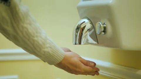 The man dries his hands under a stream of hot air. Hand dryer Stock Footage 86982470