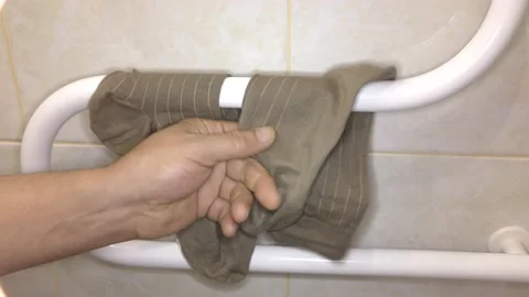 Man dries socks on a drying coil. Stock Footage 132730813