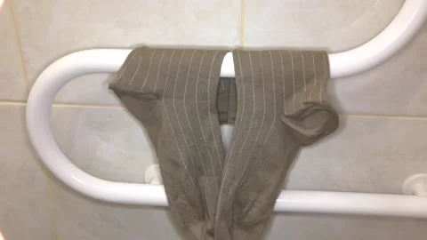 Man dries socks on a drying coil. Stock Footage 132730871