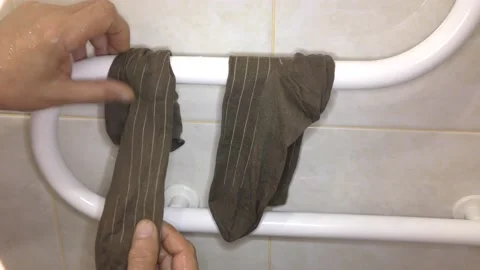 Man dries socks on a drying coil. Stock Footage 132730905