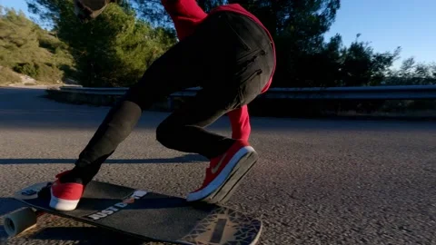Man drifting riding a longboard on sunset in a road. Skateboard Longboarding 4k Stock Footage 168190534