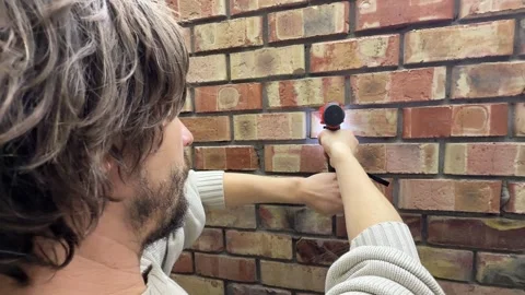 Man drilling into brick wall using power drill, construction and installation Stock Footage 337110467