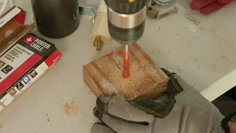 Man drilling a hole into a small block of wood Video stock 149374479
