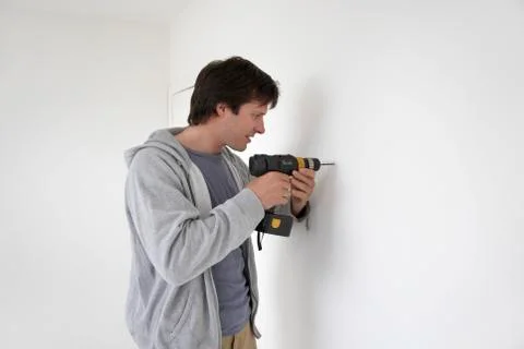 Man Drilling Hole In Wall Stock Photos
