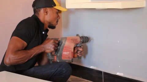 Man drilling a wall to install funiture Stock Footage 165342358