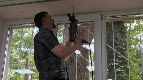 Man drilling into wooden window frame during home renovation indoors Stock Footage 342521191