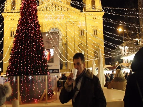 Man drining mulled wine in front of Christmas tree Stock Footage 83680020