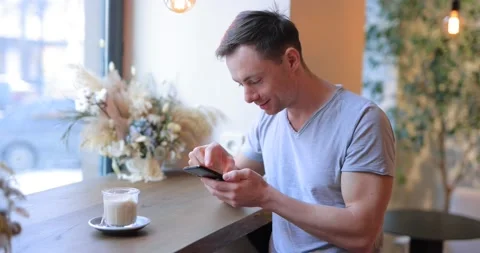 Man drink coffee in cafe and using smartphone Stock Footage 151086752