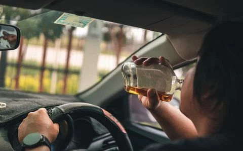 Man drinking alcohol while driving in his car Stock Photos