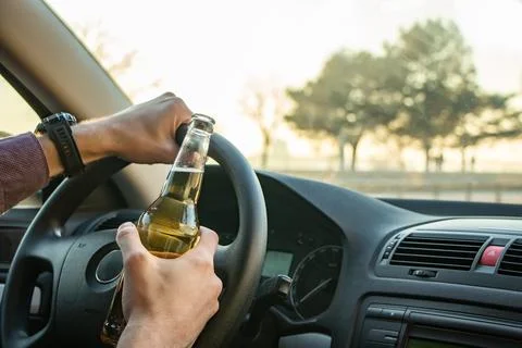 Man drinking alcohol while driving in his car Fotos Stock