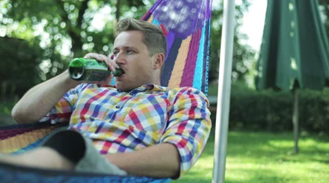 Man drinking beer and lying in the hammock Stock-Footage 33911575