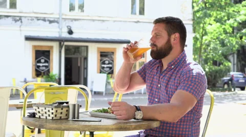 Man drinking beer during lunch and smiling for camera Vídeos de archivo 67627564