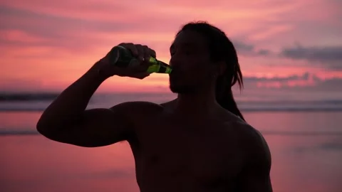 Man Drinking Beer at Sea Beach Sunset or Person Drinks Beverage at Ocean Water Video stock 258422451