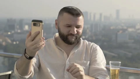 Man drinking beer in the skybar and doing selfies on smartphone Stock Footage 93232299