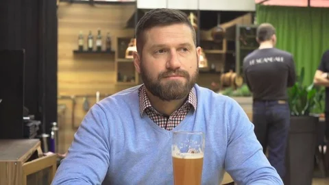 Man drinking beer watching ceiling, portrait, in pub, cafe, steadicam shot. Vídeos de archivo 73066845