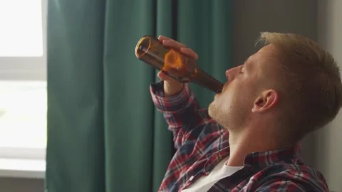 Man drinking a bottle of beer at home. Stock Footage 221261278