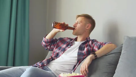 Man drinking a bottle of beer at home. Stock Footage 221261328